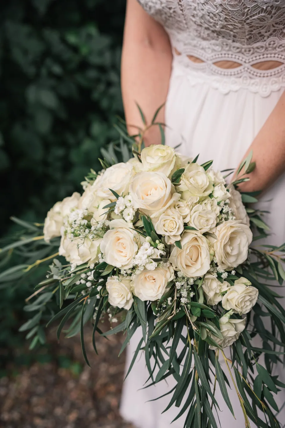 A bride holding an ivory rose bouquet